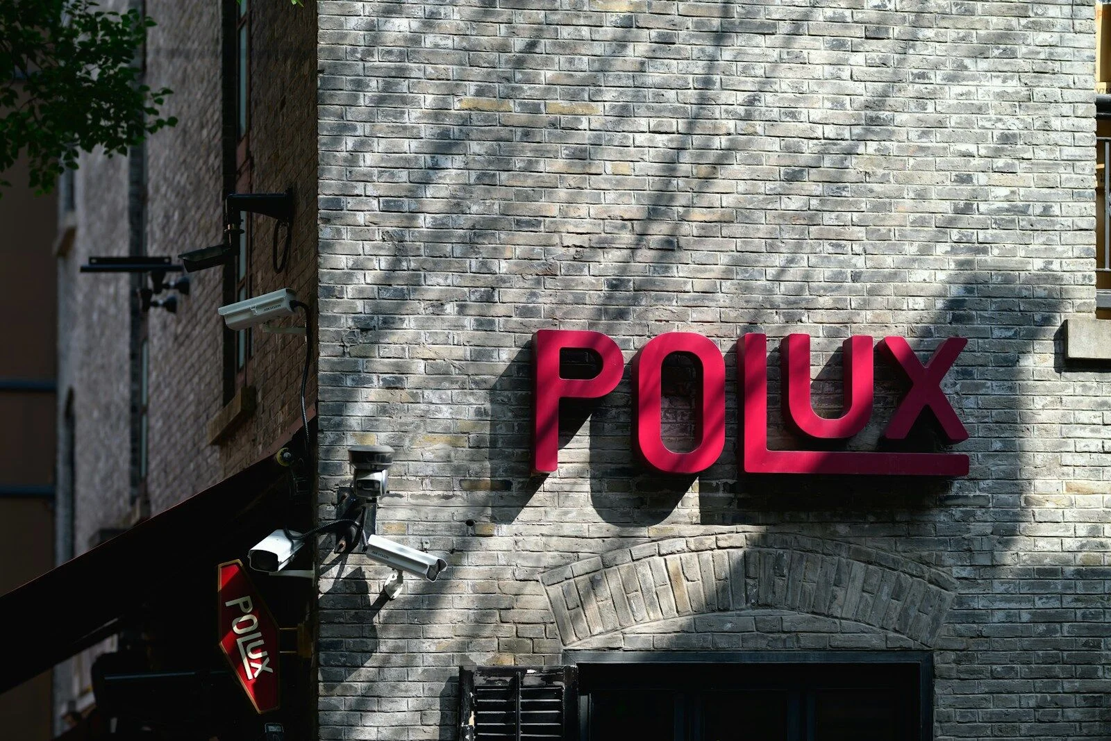 Mur de logos et signalétique urbaine — collection de marques côte à côte sur façade.